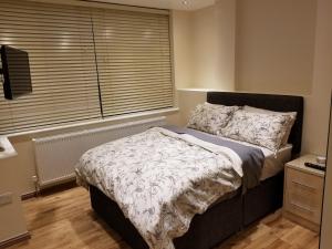 a bedroom with a bed and a large window at London Luxury Apartments 1 min from Redbridge Station with Parking in Wanstead