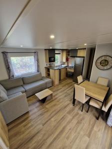ein Wohnzimmer mit einem Sofa und einem Tisch in der Unterkunft spacieux mobil-home 3 ch in Saint-Jean-de-Monts