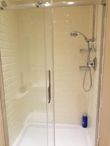 y baño con ducha y puerta de cristal. en London Luxury Apartments 1 min from Redbridge Station with Parking, en Wanstead