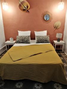 um quarto com uma cama grande e um cobertor amarelo em Déjeuner au bord de l'eau em Sommières