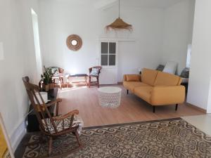 a living room with a couch and a chair at Déjeuner au bord de l'eau in Sommières