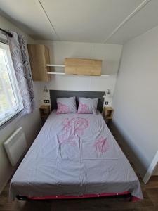 a bedroom with a large bed with pink pillows at spacieux mobil-home 3 ch in Saint-Jean-de-Monts +20 photos