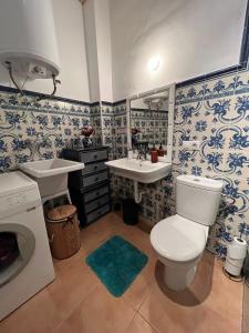 a bathroom with a toilet and a sink and a washing machine at Oldtown family house with amazing terrace - 3 minutes from beach! in Villajoyosa +37 photos