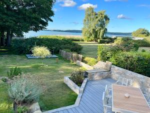 einen Garten mit einer Holzbank und einem Tisch in der Unterkunft Das Sellin - Auszeit mit eigenem Seezugang und Sonnengarten in Heringsdorf