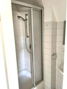 a shower with a glass door in a bathroom at Ruhiges Zimmer nahe Therme & Kurpark in Bad Steben
