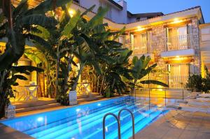 a hotel with a swimming pool in front of a building at Giritlim Otel in Çeşme