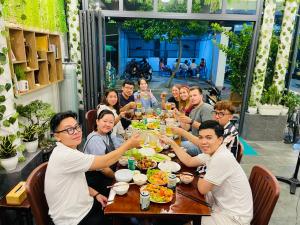 un grupo de personas sentadas alrededor de una mesa comiendo comida en Duy Cảnh Homestay en Con Dao