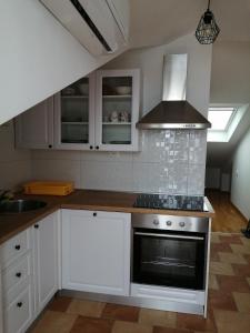 a kitchen with white cabinets and a stove top oven at Lina in Gradac