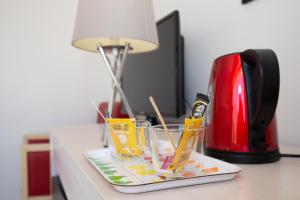 a tray with glasses on a counter next to a coffee maker at Hôtel Ker-Noyal Quiberon Plage in Quiberon