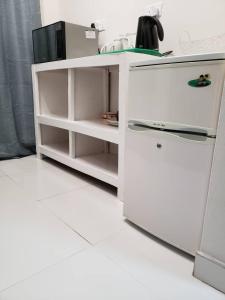 una cucina con bancone bianco e frigorifero di Kasuda - self contained room in Livingstone a Livingstone