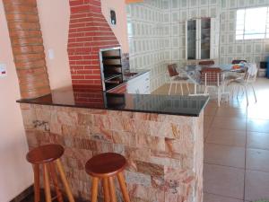 a kitchen with a brick fireplace and some stools at Chácara isabella in Socorro