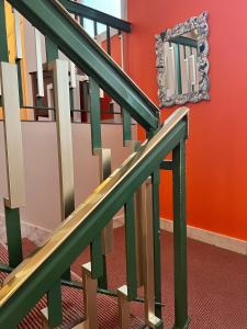 a staircase with green railings and a mirror on the wall at Hôtel Ker-Noyal Quiberon Plage in Quiberon