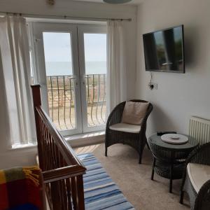 a living room with a view of the ocean at Beachfront Studio in Pevensey