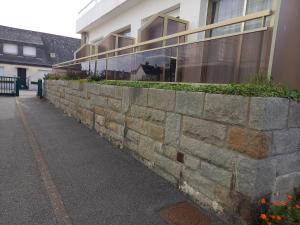 a stone retaining wall in front of a building at Hôtel Ker-Noyal Quiberon Plage in Quiberon