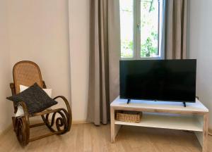 a flat screen tv sitting on a tv stand next to a chair at Gerwies-Hof in Bronzolo