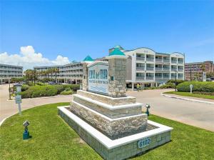 a stone monument in front of a large building at Sea Chase with an ocean view at Casa Del Mar in Galveston