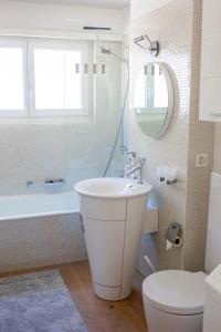 łazienka z umywalką, wanną i toaletą w obiekcie Traumhafte Sonnenresidenz mit Berg- und Seeblick w mieście Amden