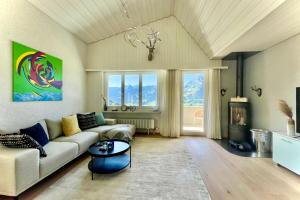 ein Wohnzimmer mit einem Sofa und einem Tisch in der Unterkunft Traumhafte Sonnenresidenz mit Berg- und Seeblick in Amden