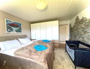 Un dormitorio con una cama con carpetas azules. en Traumhafte Sonnenresidenz mit Berg- und Seeblick, en Amden