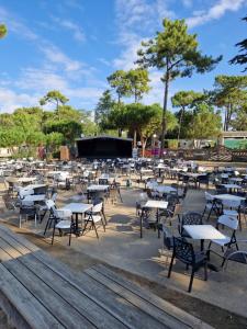 a group of tables and chairs with a stage in the background at spacieux mobil-home 3 ch in Saint-Jean-de-Monts