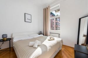 biała sypialnia z łóżkiem i ręcznikami w obiekcie A&S Center Apartment Vienna w Wiedniu
