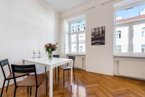 - une salle à manger blanche avec une table et des chaises blanches dans l'établissement A&S Center Apartment Vienna, à Vienne