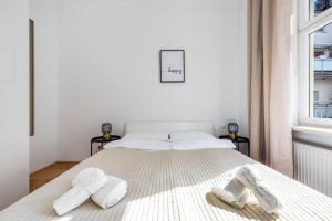a white bedroom with a bed with two slippers on it at A&S Center Apartment Vienna in Vienna
