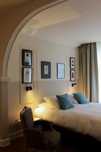 a bedroom with a bed and a chair next to a window at Huis Dujardin Bed&Breakfast in Antwerp