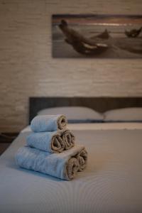 una pila di asciugamani poggiata sopra un letto di La casa di Anna green a Domegliara