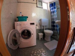 uma casa de banho com uma máquina de lavar roupa e um WC em Anna’s house em Síndos