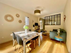 a dining room with a table and a couch at Gîte tout confort entre Marmande et Tonneins in Birac-sur-Trec