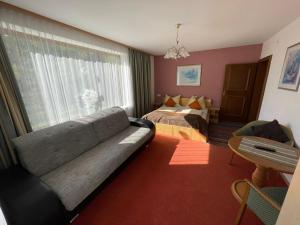 ein Wohnzimmer mit einem Sofa und einem Bett in der Unterkunft Appartment Sonnenschein in Uttendorf