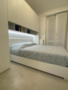 1 dormitorio con 1 cama y armarios blancos en Lady Indigo San Siro, en Milán