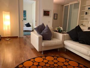 een woonkamer met 2 banken en een tapijt bij Maison de Maff in Pesaro