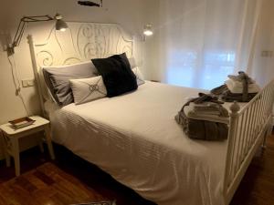a bedroom with a white bed with a white headboard at Maison de Maff in Pesaro