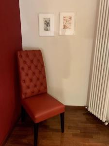 a red chair sitting in a corner of a room at Maison de Maff in Pesaro