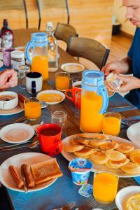 a table topped with plates of breakfast foods and orange juice at Hudhuvelimaldives in Omadhoo
