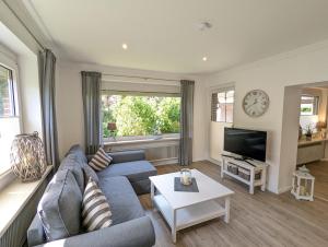 a living room with a couch and a tv at Das Inselhaus in Norddeich
