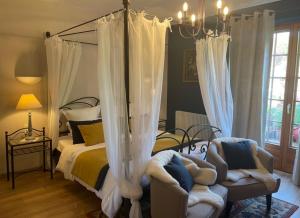 - une chambre avec un lit à baldaquin et 2 chaises dans l'établissement Hotel Kieffer, à Itterswiller