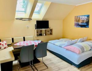 a bedroom with two beds and a table and a tv at Ferienwohnung Lange in Göstling an der Ybbs