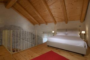 a bedroom with a white bed and a wooden ceiling at Cà 'd Calin Casa nel Borgo in Serralunga d'Alba