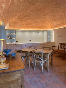 eine Küche mit Holztischen und -stühlen in einem Zimmer in der Unterkunft Relais Maria Cristina in Chianni