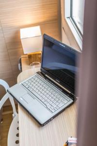 a laptop computer sitting on top of a wooden table at Europe Hotel Vieux Port in Marseille