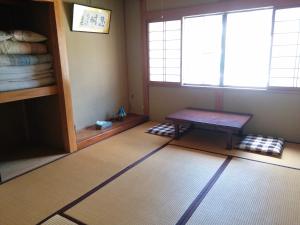 um quarto vazio com uma mesa e uma janela em Matsuo House - Max 3 person Room Haru em Zao Onsen