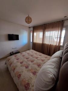 a bedroom with a bed and a television in it at Appartement pied dans l'eau imi Ouaddar in Imi Ouaddar