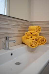 - une serviette jaune assise au-dessus d'un lavabo dans l'établissement La casa di Anna, à Domegliara 27 autres photos