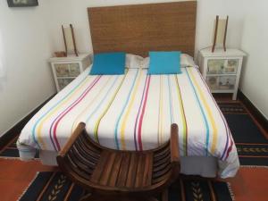 um quarto com uma cama e uma cadeira de madeira em Apartment over the Ocean em Sesimbra