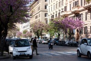 una concurrida calle de la ciudad con coches y una persona en motocicleta en Florida rooms - comfort Hotel en Roma