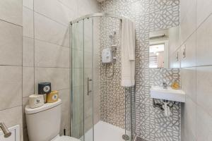 een badkamer met een douche, een toilet en een wastafel bij Elegant Studio - Perfect for Explorers in Londen