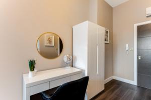 a white dressing room with a mirror and a chair at Elegant Studio - Perfect for Explorers in London